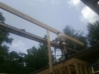 Carpenter setting a ridge beam over a new addition frame — Ice Dam Removal by Roofing Brothers in Parkers Lake