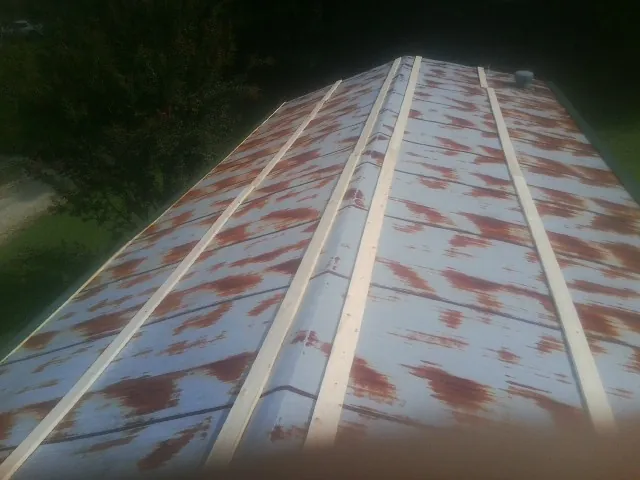 Rusted metal roof panels with new wood purlins before replacement — Storm Damage Roof Repair in Parkers Lake by Roofing Brothers