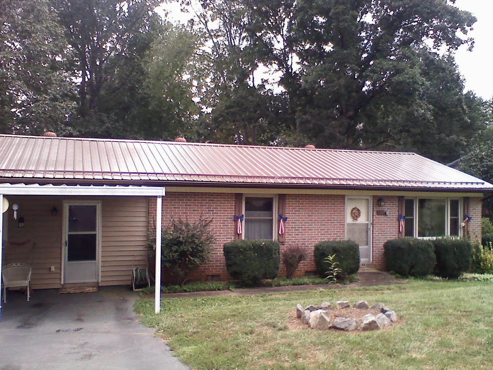 Bronze metal roof and carport on a brick ranch home — Roof Repair work by our crew in Parkers Lake